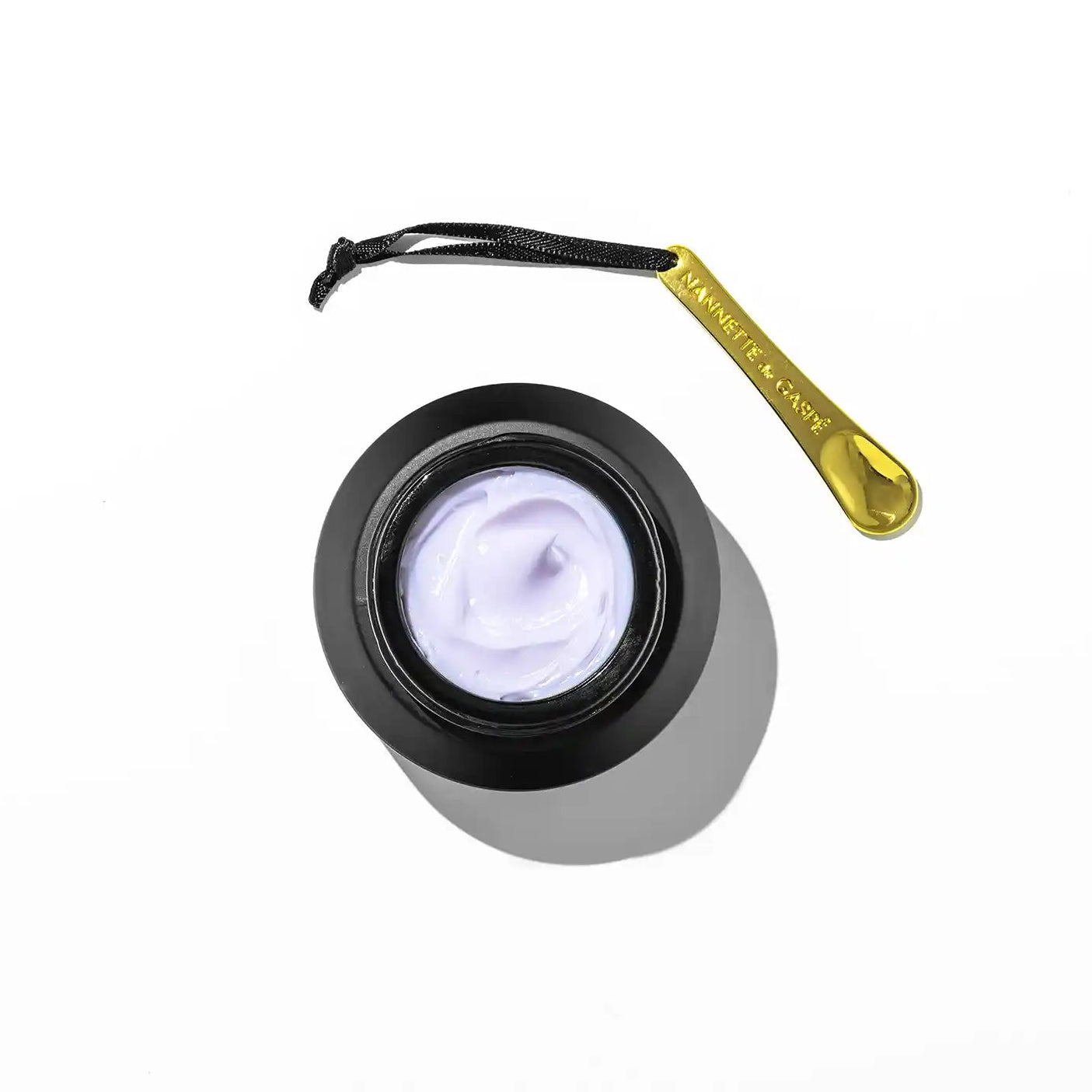 Cosmetic cream jar with a spoon on a white background