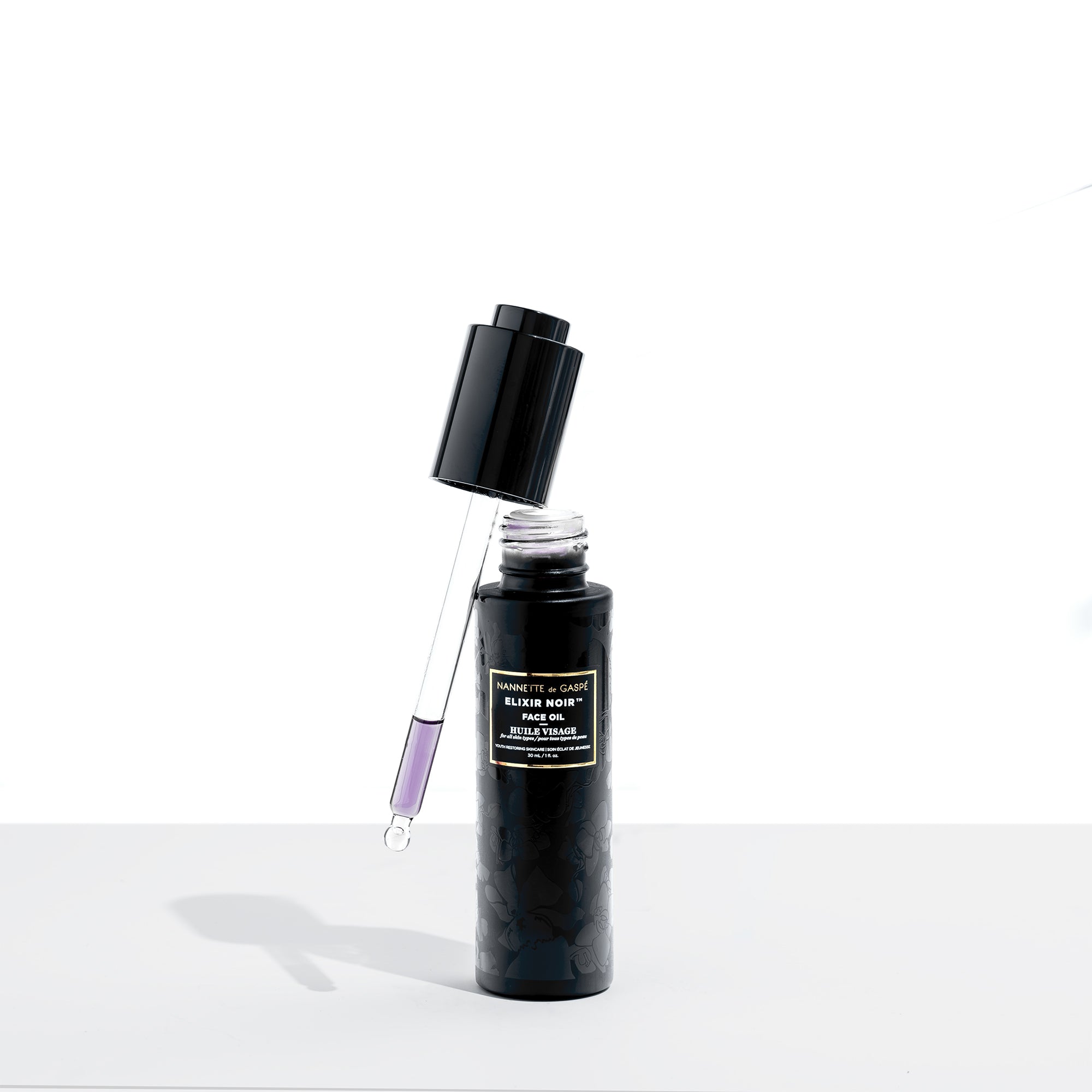 Elixir Noir Face Oil with dropper—lightweight, serum-like texture designed to absorb quickly